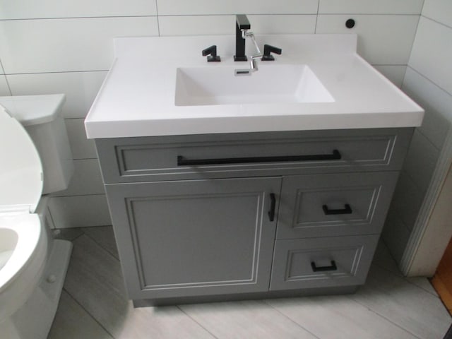3805 Euclid Ave, Berwyn, IL 60402 - bathroom with tile walls, vanity, toilet, and tile patterned floors