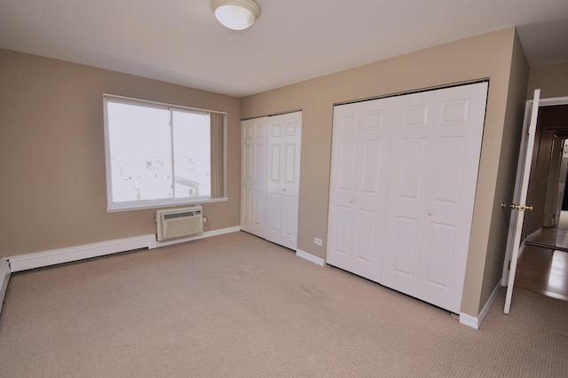 1227 S Harlem Ave Unit 511, Berwyn, IL 60402 - unfurnished bedroom with baseboards, a baseboard heating unit, light carpet, multiple closets, and a wall unit AC