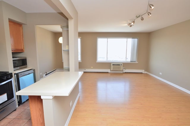 1227 S Harlem Ave Unit 511, Berwyn, IL 60402 - kitchen featuring a center island, a wall mounted air conditioner, light countertops, appliances with stainless steel finishes, and light wood finished floors