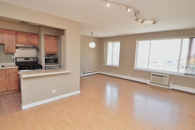 1227 S Harlem Ave Unit 511, Berwyn, IL 60402 - kitchen with stainless steel appliances, under cabinet range hood, an AC wall unit, and light countertops