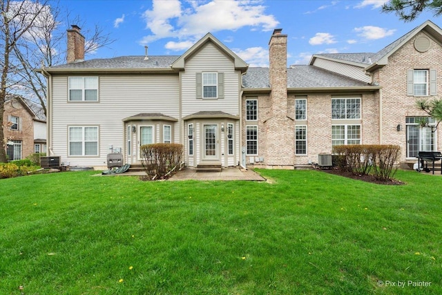 2097 Ivy Ridge Dr Unit 2097, Hoffman Estates, IL 60192 - back of house with a chimney, a patio, cooling unit, and a lawn