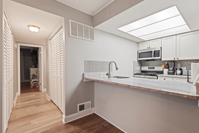 9830 Sayre Ave Unit 6, Chicago Ridge, IL 60415 - kitchen with visible vents, stainless steel gas range oven, light stone counters, and a sink