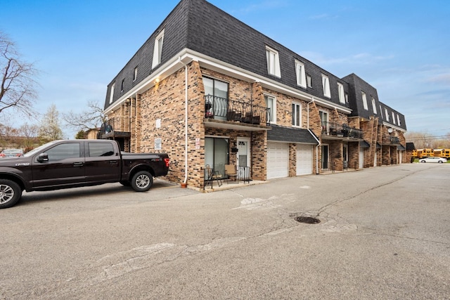 9830 Sayre Ave Unit 6, Chicago Ridge, IL 60415 - view of side of property featuring a balcony, brick siding, roof with shingles, an attached garage, and mansard roof