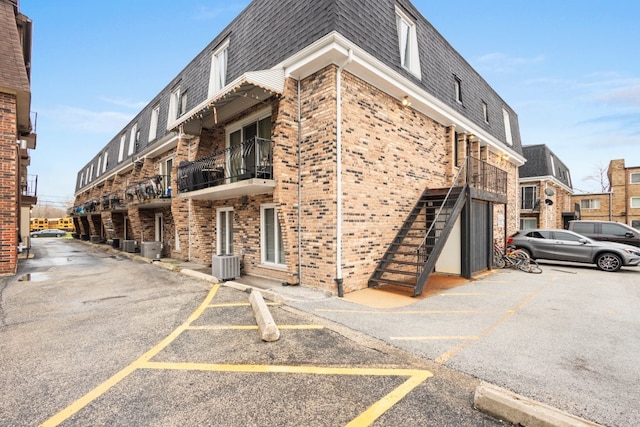 9830 Sayre Ave Unit 6, Chicago Ridge, IL 60415 - view of building exterior featuring central air condition unit and uncovered parking