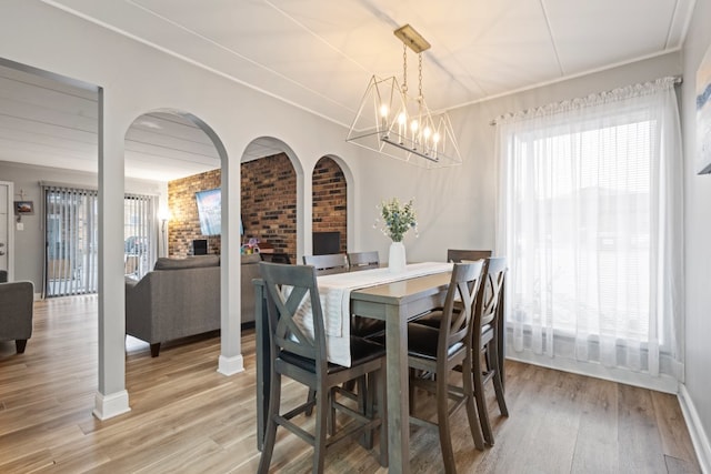 9830 Sayre Ave Unit 6, Chicago Ridge, IL 60415 - dining space featuring light wood-style floors, a chandelier, baseboards, brick wall, and ornamental molding