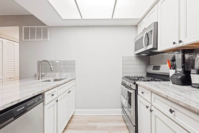 9830 Sayre Ave Unit 6, Chicago Ridge, IL 60415 - kitchen with decorative backsplash, appliances with stainless steel finishes, a sink, white cabinetry, and visible vents