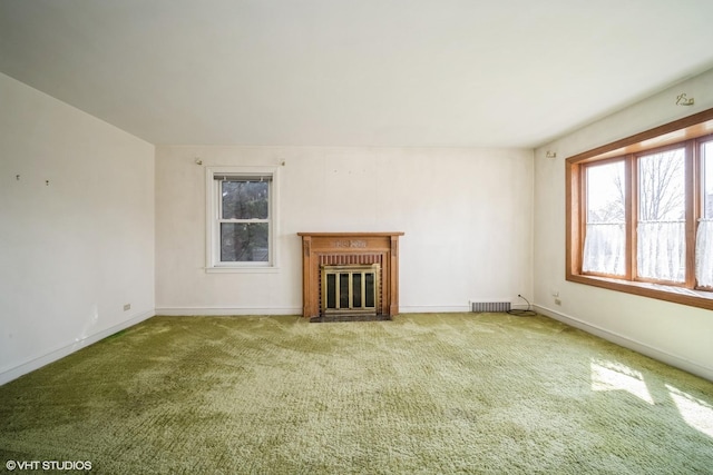 unfurnished living room with carpet, visible vents, baseboards, and a brick fireplace