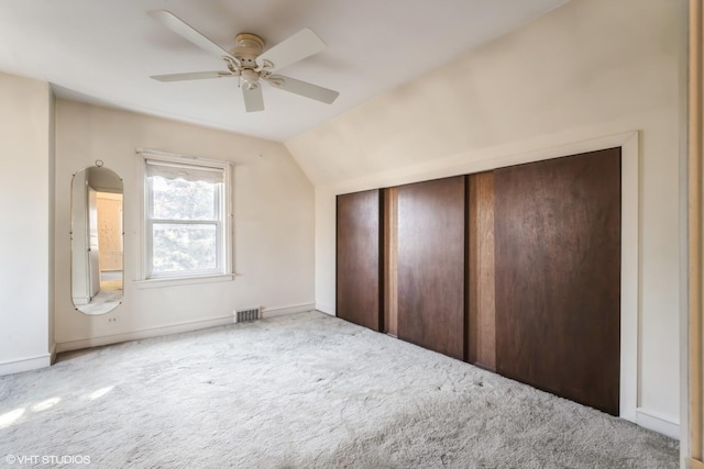 additional living space featuring visible vents, a ceiling fan, carpet flooring, and vaulted ceiling