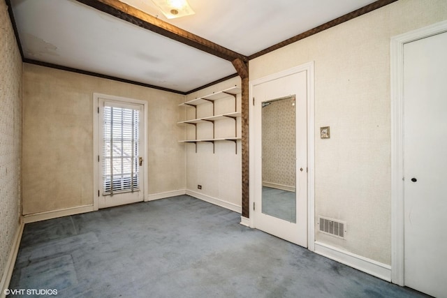 empty room featuring visible vents, baseboards, ornamental molding, beam ceiling, and carpet flooring