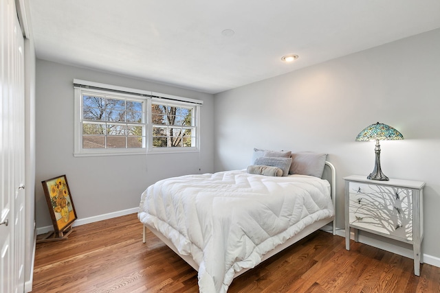 bedroom with baseboards and wood finished floors