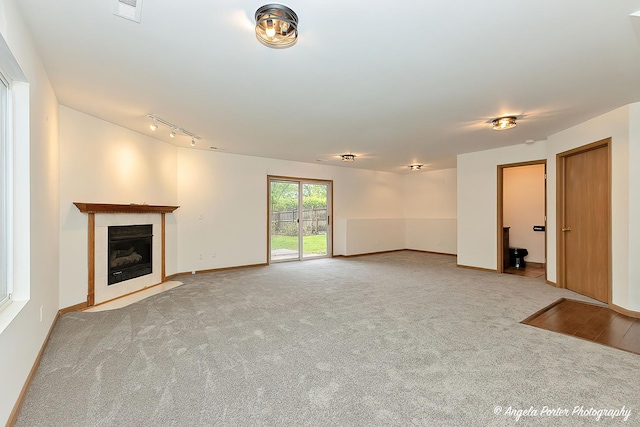 35850 N Benjamin Ave, Ingleside, IL 60041 - unfurnished living room with a tiled fireplace, carpet flooring, baseboards, and rail lighting