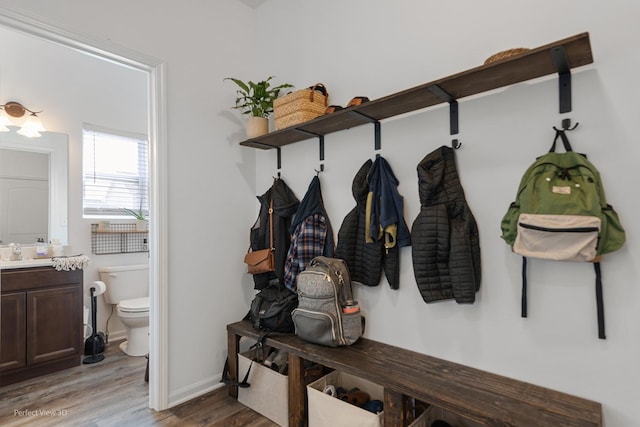 mudroom featuring light wood-style floors, baseboards, and a sink
