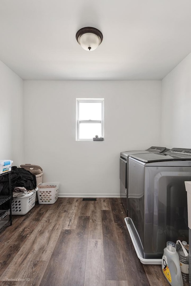 laundry area featuring washer and dryer, dark wood-style floors, and baseboards