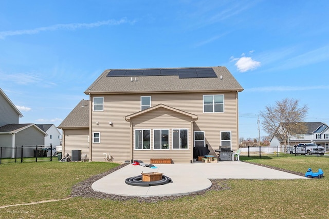 back of property featuring an outdoor fire pit, a patio area, solar panels, central AC, and a shingled roof