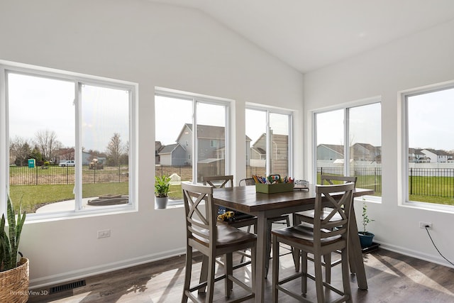 sunroom with vaulted ceiling and a residential view