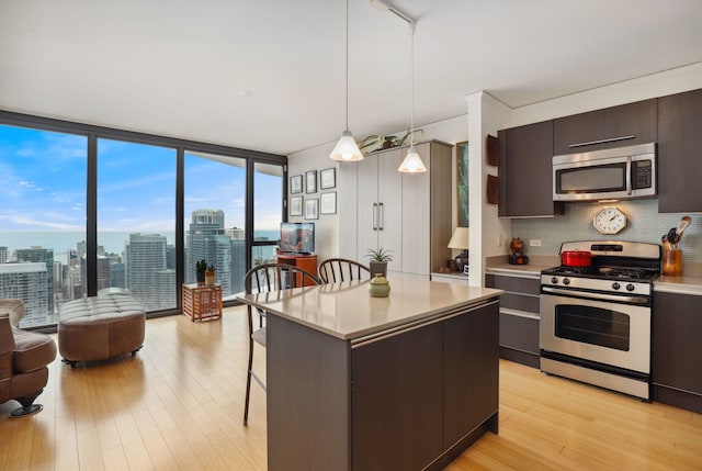 225 N Columbus Dr Unit 5305, Chicago, IL 60601 - kitchen featuring stainless steel appliances, light wood-type flooring, a breakfast bar, light countertops, and backsplash