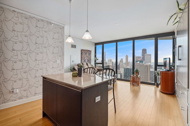 225 N Columbus Dr Unit 5305, Chicago, IL 60601 - kitchen featuring expansive windows, light wood-style flooring, a breakfast bar, a center island, and decorative light fixtures