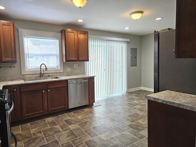 kitchen with recessed lighting, light countertops, a sink, stainless steel appliances, and baseboards