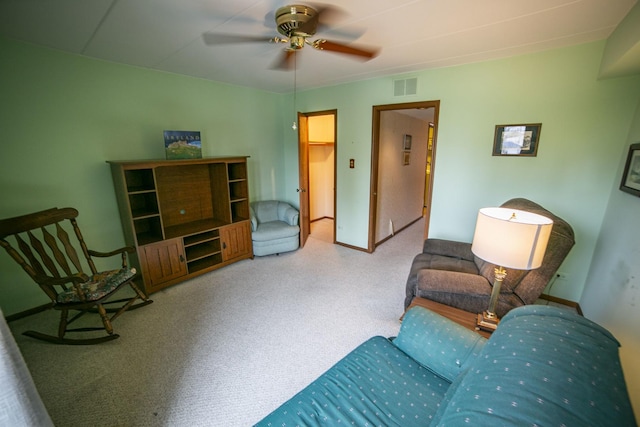 living area featuring carpet flooring, visible vents, and ceiling fan