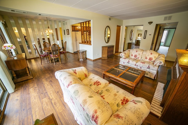 living area with visible vents, a notable chandelier, and hardwood / wood-style flooring