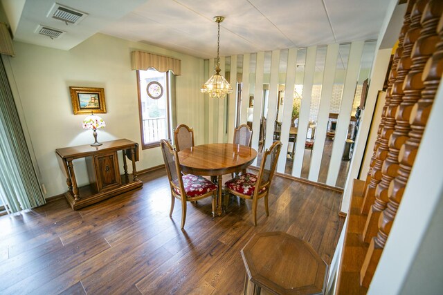 dining area with an inviting chandelier, wood-type flooring, and visible vents
