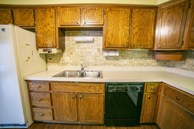 kitchen featuring light countertops, freestanding refrigerator, a sink, and black dishwasher