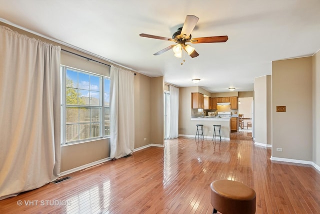 271 Valley Forge Ave, South Elgin, IL 60177 - unfurnished living room featuring baseboards, visible vents, a ceiling fan, and light wood finished floors