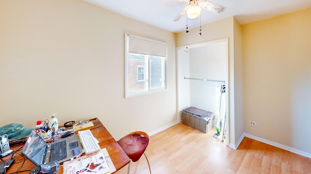 home office with baseboards, light wood finished floors, and a ceiling fan