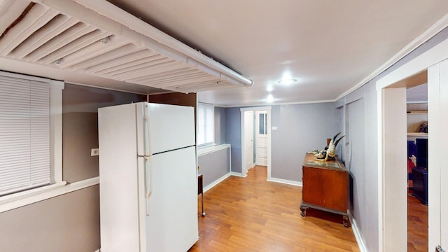 kitchen featuring baseboards, freestanding refrigerator, and light wood finished floors