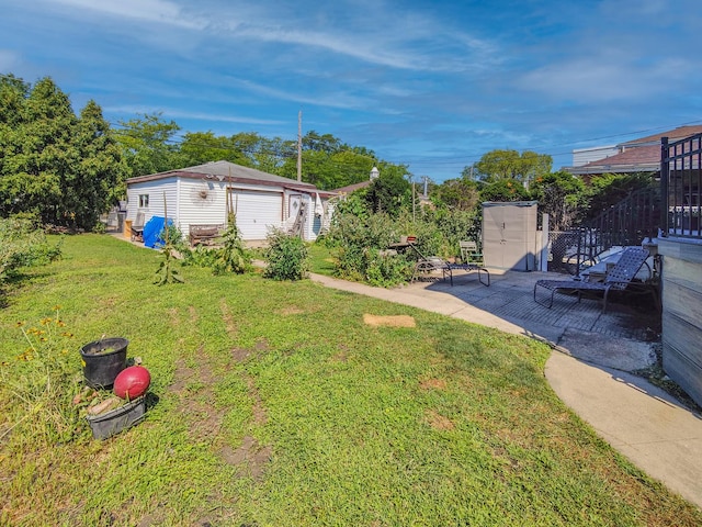 view of yard featuring a patio area, fence, and an outdoor structure