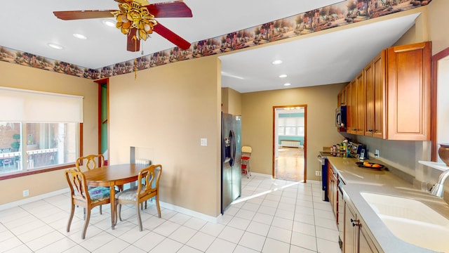 kitchen featuring baseboards, a ceiling fan, brown cabinets, appliances with stainless steel finishes, and a sink