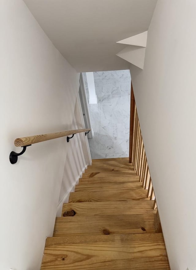 stairway featuring marble finish floor