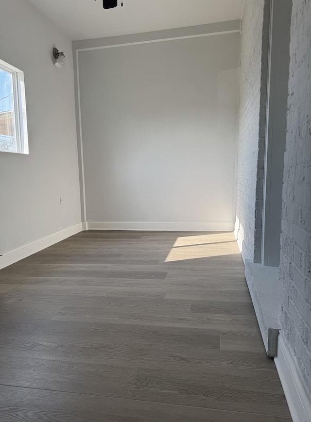 unfurnished room featuring baseboards and dark wood finished floors