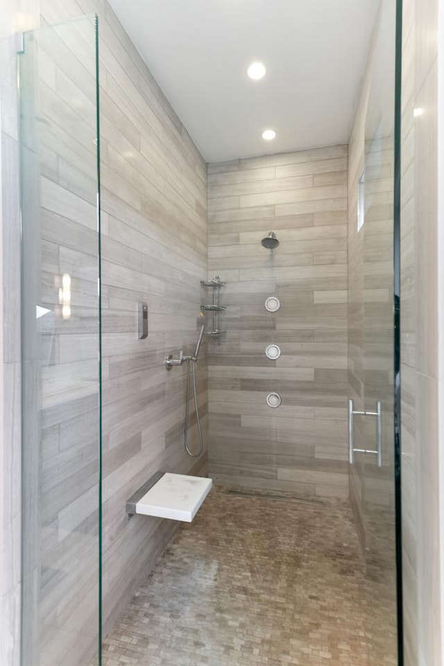 bathroom with tiled shower and recessed lighting