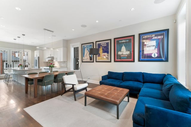 living room with light wood-style floors, baseboards, and recessed lighting