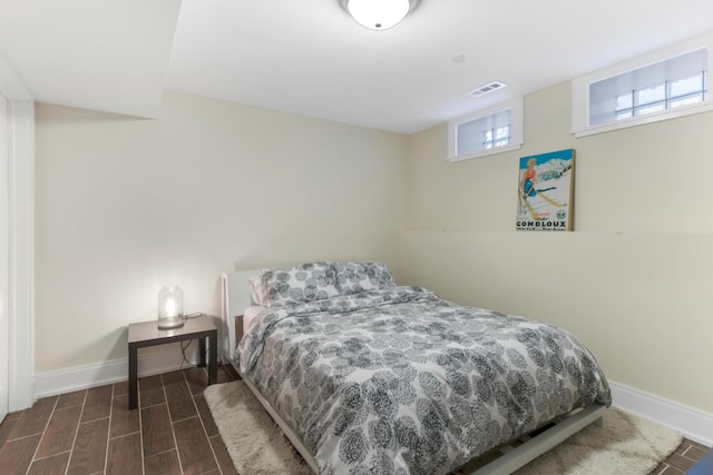 bedroom with dark wood-style floors, baseboards, and visible vents