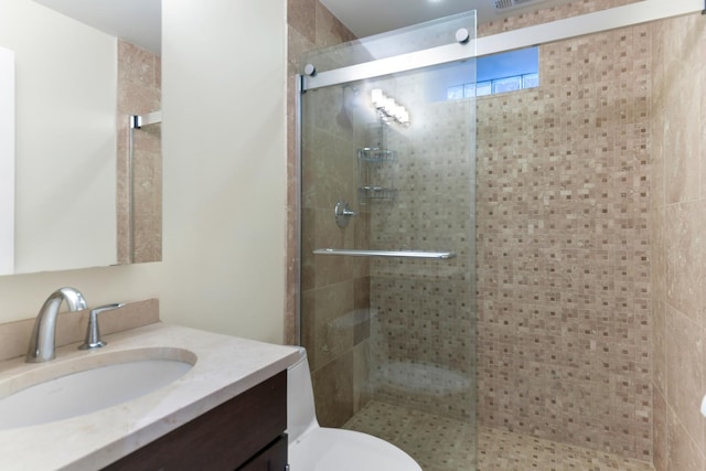 bathroom featuring a shower stall, vanity, and toilet