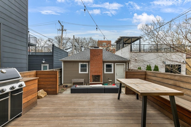wooden terrace with outdoor lounge area, a grill, and an outdoor kitchen