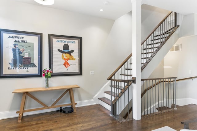 staircase with wood finished floors, baseboards, and visible vents