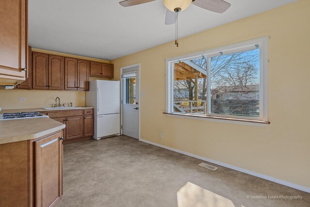 308 Eaton Ave, Romeoville, IL 60446 - kitchen with visible vents, baseboards, a sink, light countertops, and freestanding refrigerator