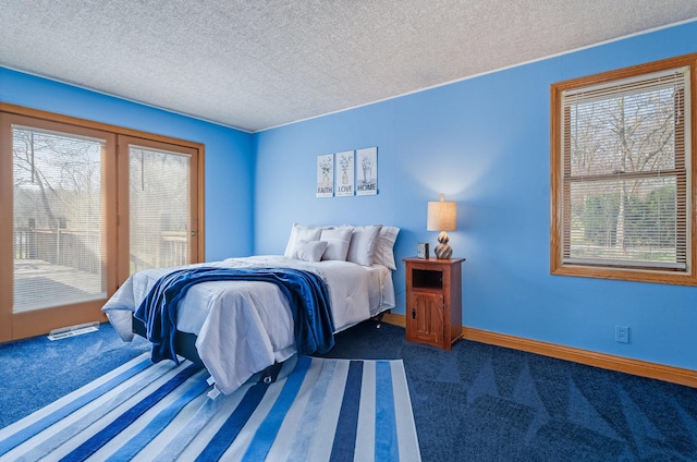 bedroom featuring a textured ceiling, dark colored carpet, and multiple windows