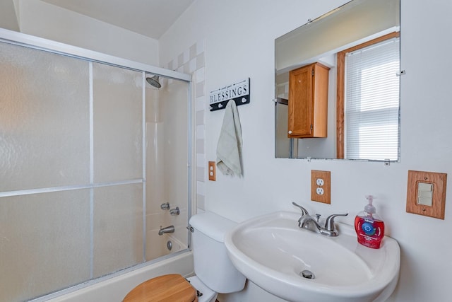 full bathroom with enclosed tub / shower combo and a sink