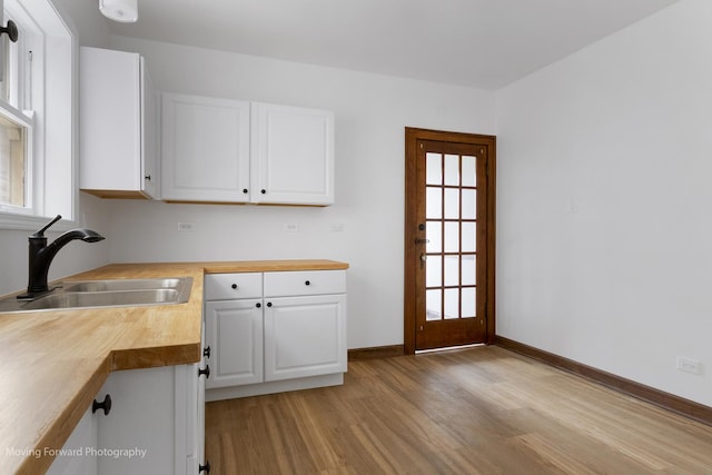 1916 Kenilworth Ave, Berwyn, IL 60402 - kitchen with butcher block countertops, light wood-type flooring, a sink, and white cabinets
