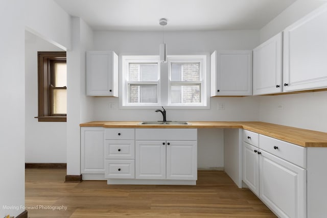 1916 Kenilworth Ave, Berwyn, IL 60402 - kitchen with a sink, white cabinetry, wood counters, pendant lighting, and light wood-style flooring