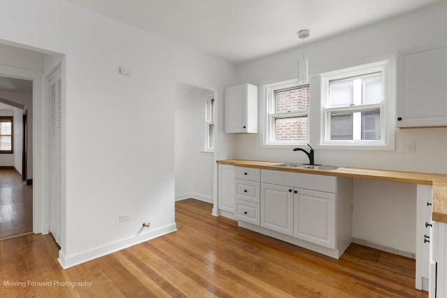 1916 Kenilworth Ave, Berwyn, IL 60402 - kitchen featuring light wood-style floors, white cabinetry, a sink, butcher block countertops, and baseboards