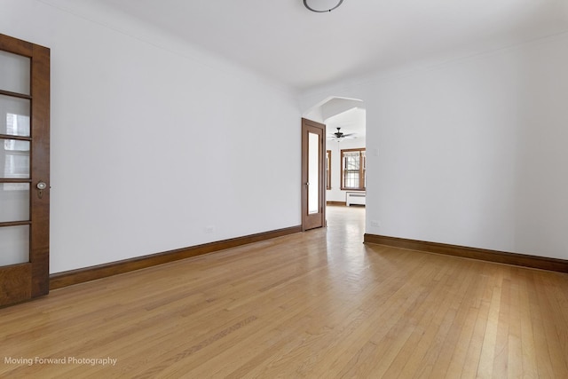 1916 Kenilworth Ave, Berwyn, IL 60402 - empty room with light wood-type flooring, a baseboard heating unit, baseboards, and arched walkways