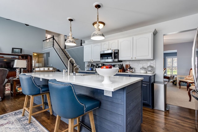 2219 Barrett Dr, Algonquin, IL 60102 - kitchen featuring stainless steel microwave, white cabinetry, a kitchen breakfast bar, and decorative backsplash