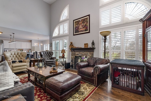 2219 Barrett Dr, Algonquin, IL 60102 - living room featuring a chandelier, a towering ceiling, wood finished floors, and a stone fireplace