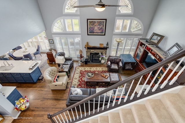 2219 Barrett Dr, Algonquin, IL 60102 - living room with a towering ceiling, ceiling fan, wood finished floors, a stone fireplace, and stairway