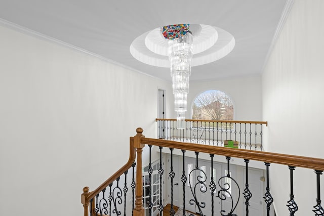 hall with an inviting chandelier and ornamental molding